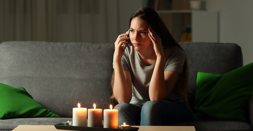 upset woman on phone with candles lit