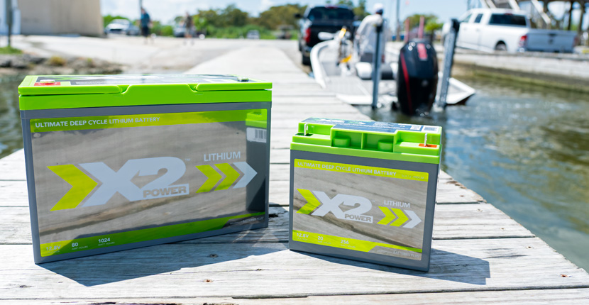 Two X2Power lithium marine batteries sitting on a pier
