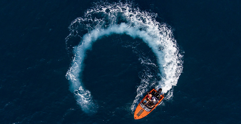Overhead shot of an orange boat turning around