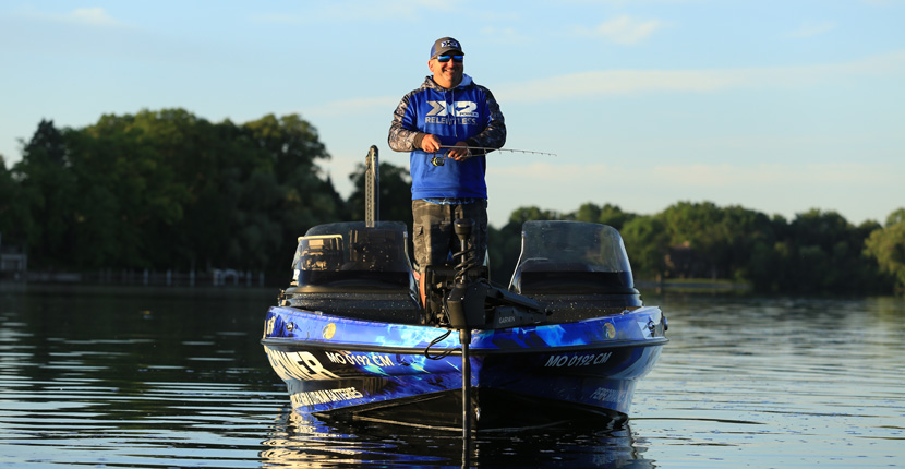 Fisherman on an X2Power wrapped boat wearing X2Power swag