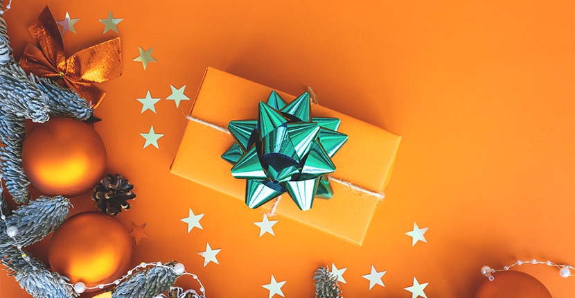 A gift wrapped in orange with a green bow