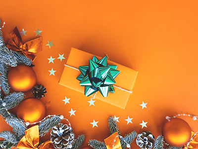 A gift wrapped in orange with a green bow